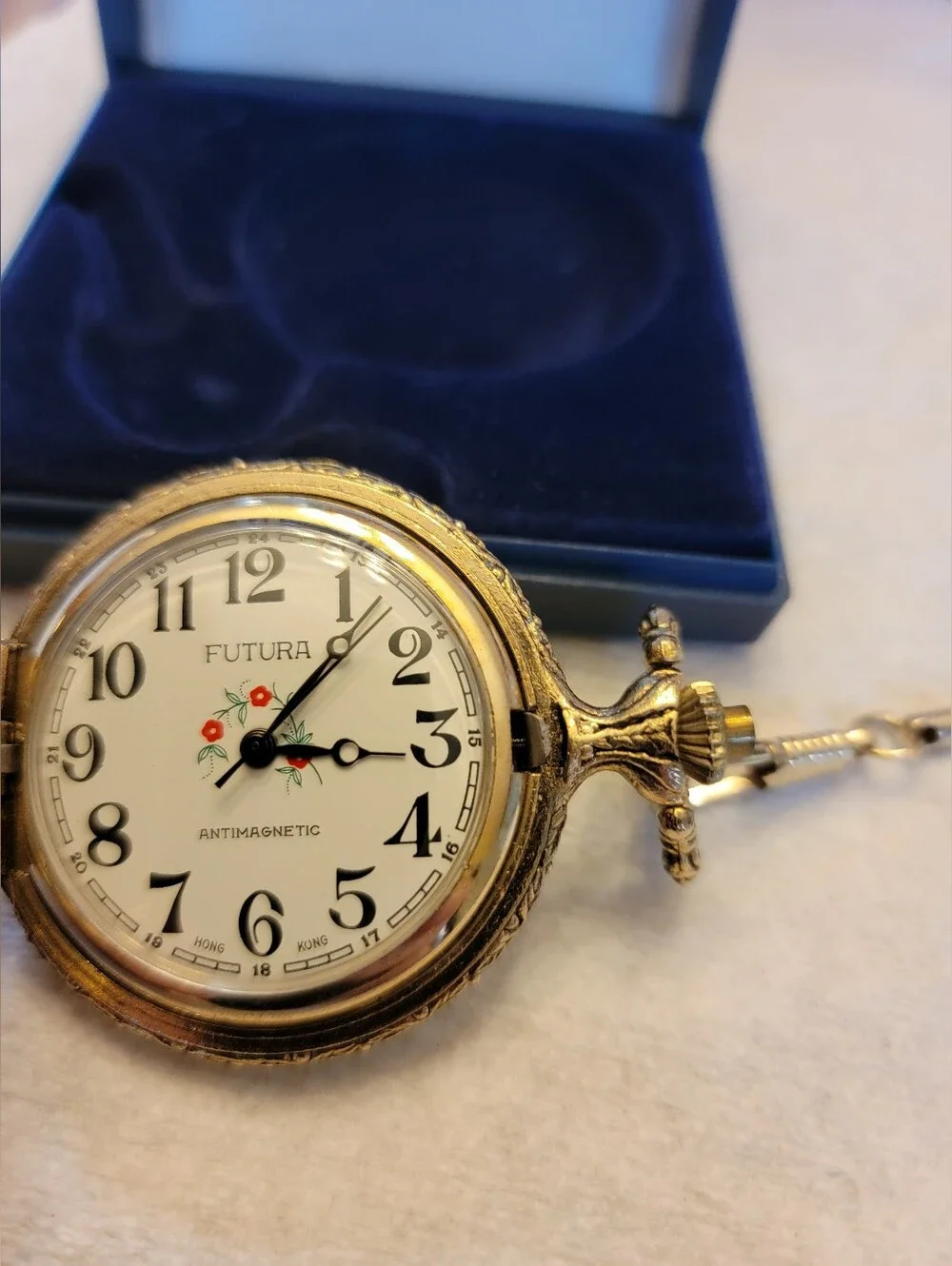 Vintage gold-tone pocket watch has a raised steam engine train motif.
